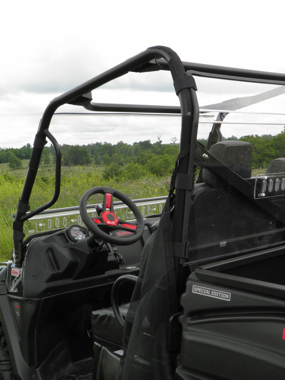 3 Star Lexan back panel clamped behind the seats of an Intimidator Classic 750, seen from the cargo bed