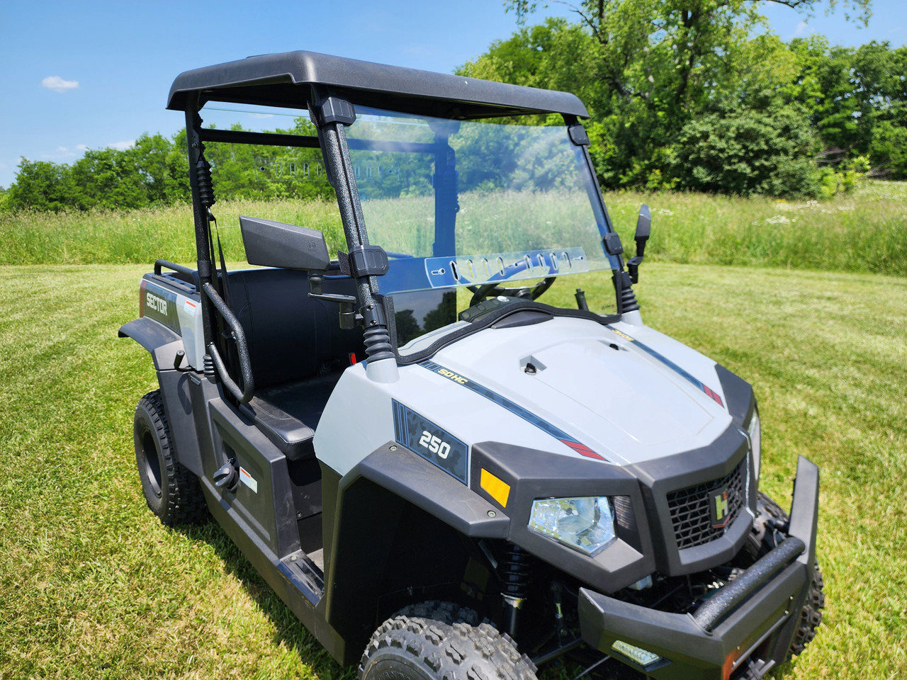 3 Star one-piece windshield on a white HiSun Sector 250 with a roof, front three-quarter view in a field