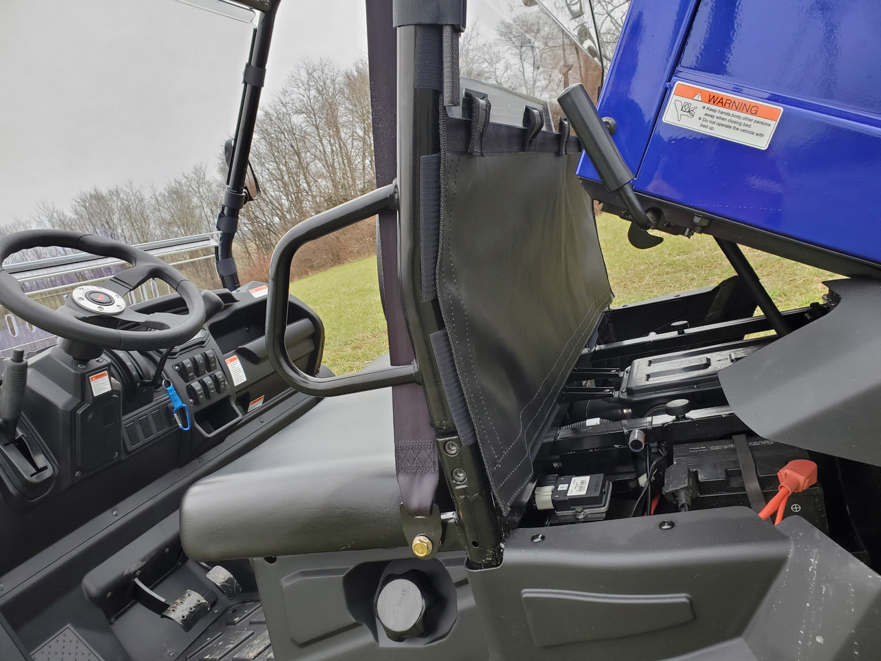 Blue Bison utility side-by-side with the bed tilted up showing the 3 Star soft lower panel behind the seat