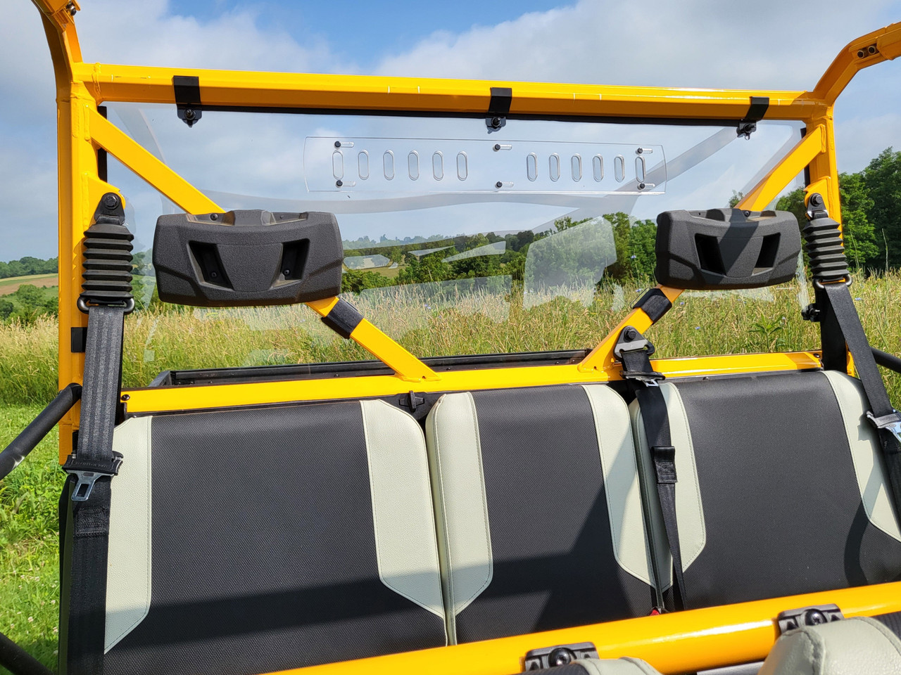 3 Star one-piece polycarbonate back panel with vent slots behind the rear seats of a crew side-by-side with a yellow cage
