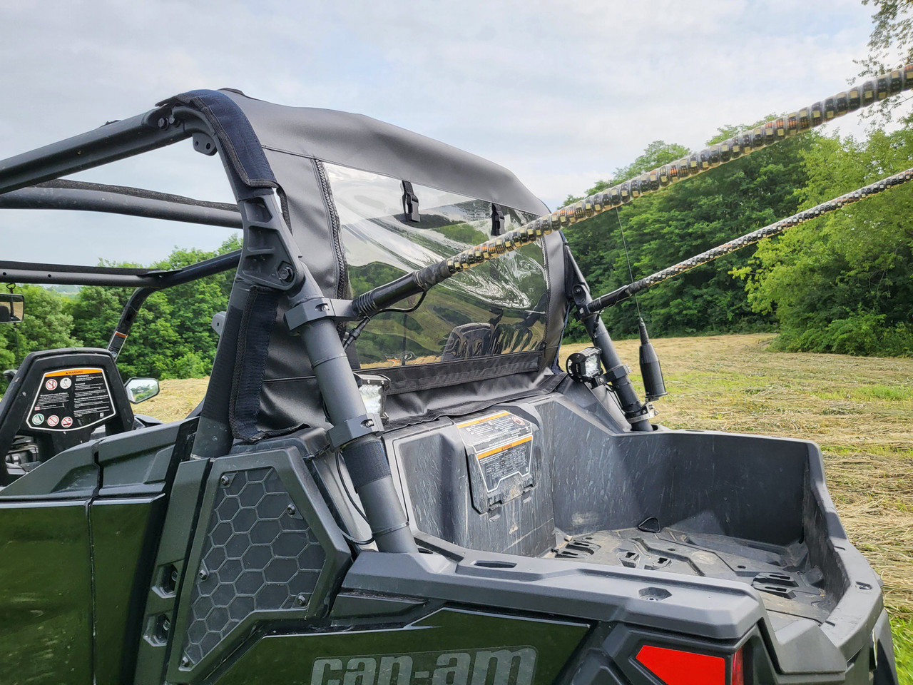 Side close-up of the 3 Star canvas rear panel and window behind the cab of a green Can-Am Maverick Trail