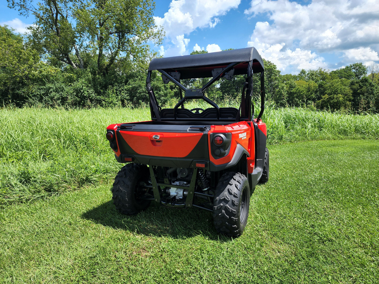 Rear view of a red Tracker Off Road 500S with the 3 Star black soft top mounted on the cage