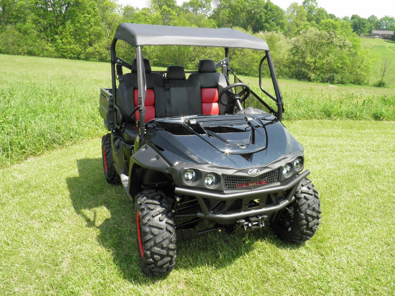 3 Star soft top on a black Intimidator Classic with red seats, front three-quarter view in a sunny field