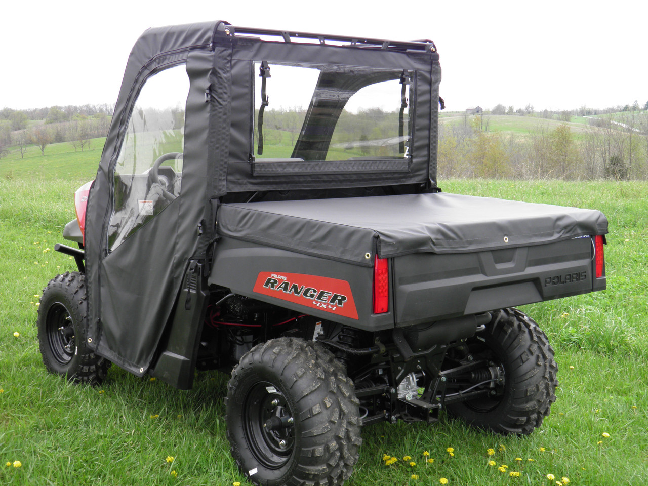 3 Star black bed cover on a Polaris Ranger 570 2-seater with cab enclosure, rear three-quarter view