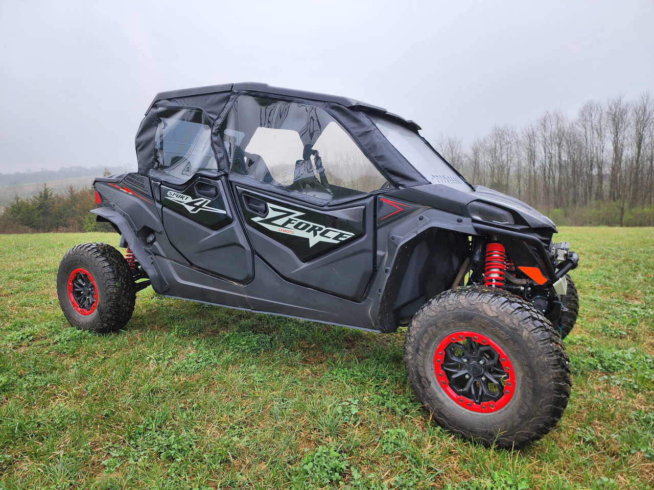3 Star soft upper doors with clear windows on a gray CFMoto ZForce Sport 4 with red wheels, side view in a foggy field