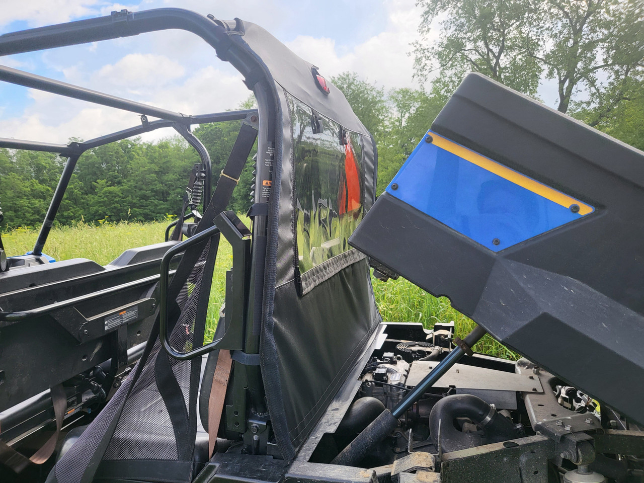 3 Star soft back panel on a New Holland 850 Crew with the bed tilted up, side view showing the black panel behind the cab