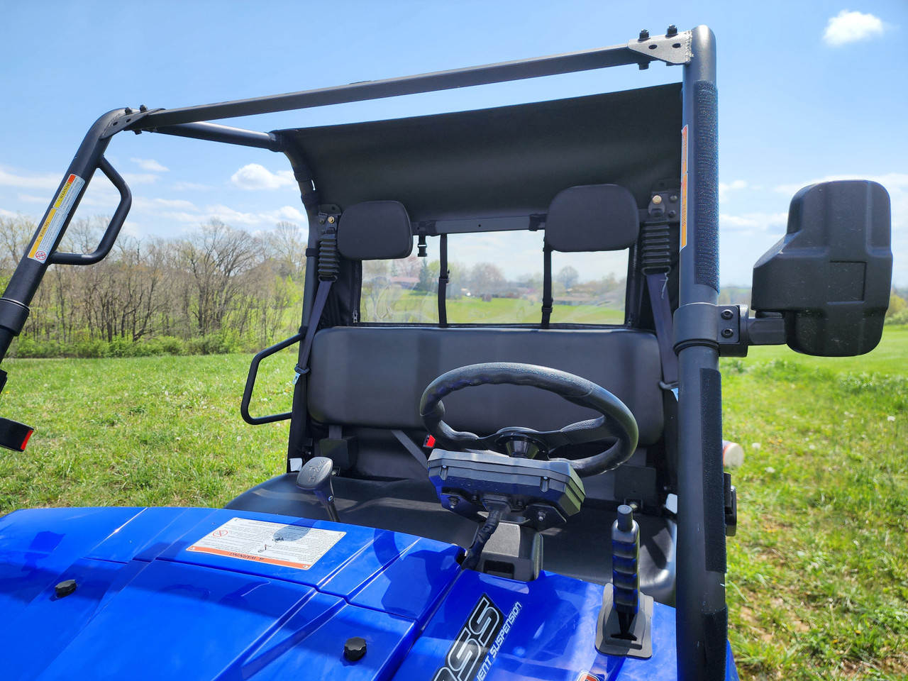 3 Star canvas rear panel with clear window behind the bench seat of a blue Massimo T-Boss 410, side view