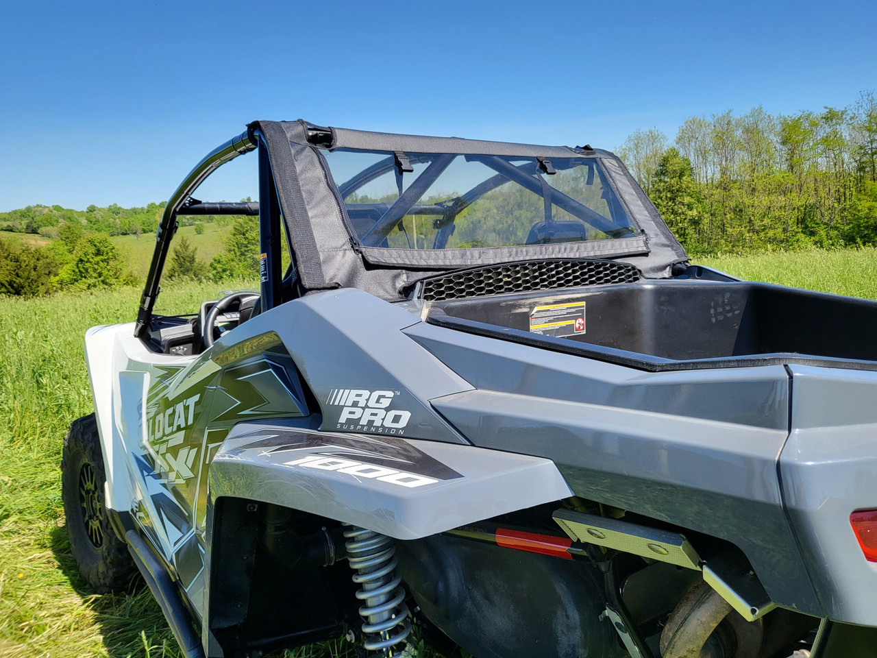 Rear three-quarter view of the 3 Star soft back panel with mesh window on a gray Arctic Cat Wildcat XX in a field