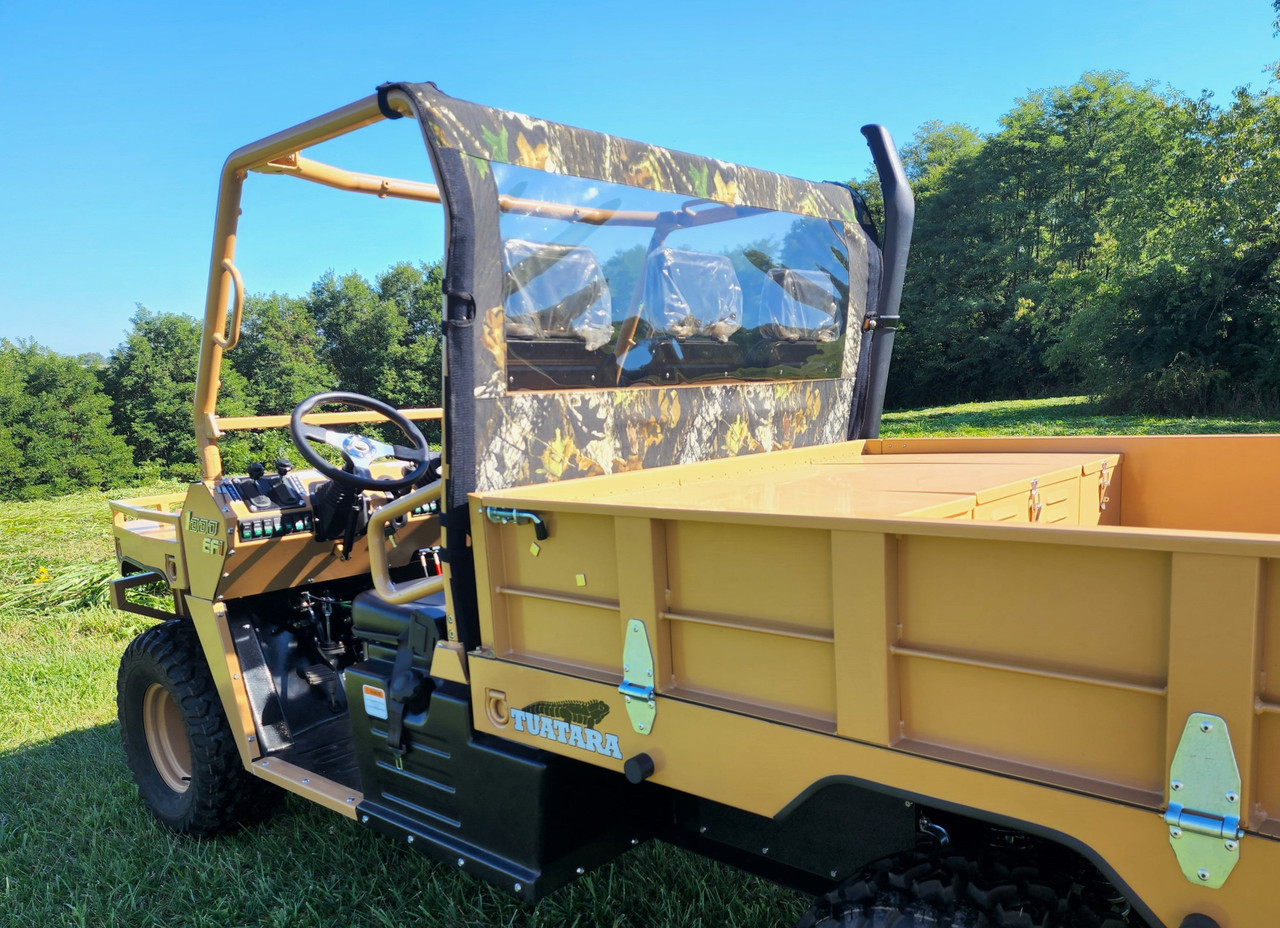 3 Star camo soft back panel with clear window behind the cab of a tan Tuatara utility vehicle, side view with the bed