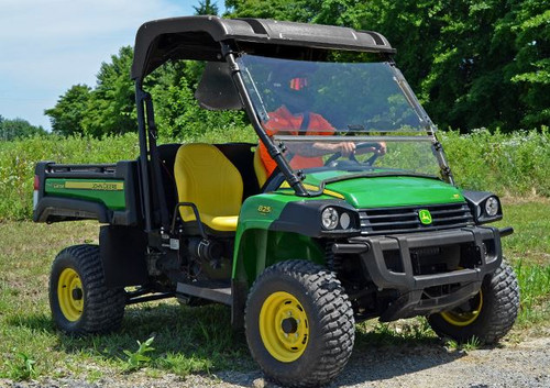 SuperATV flip-out windshield in the open position on a green John Deere Gator, side angle with driver