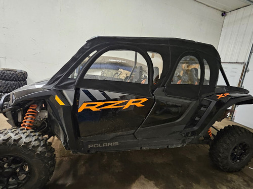 Front three-quarter view of the Side X Side upper doors on the black Polaris RZR XP4 1000 inside a shop