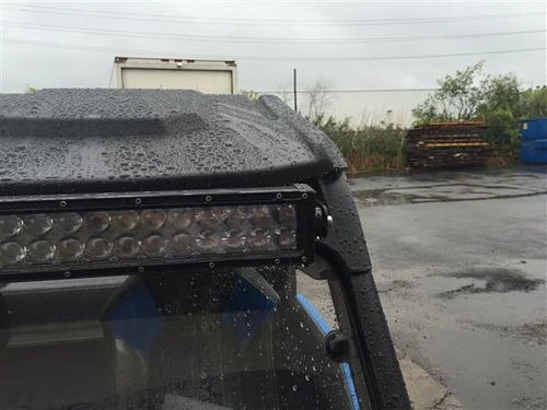 Close-up of the wet Extreme Metal Products roof front edge over the LED light bar on the Polaris General