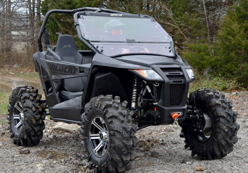 Front three-quarter view of the black Arctic Cat Wildcat Trail on gravel with the SuperATV flip-up windshield closed