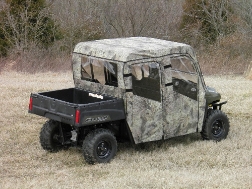 3 Star camouflage full cab enclosure on a green Polaris Ranger 700 Crew, rear three-quarter view in a field