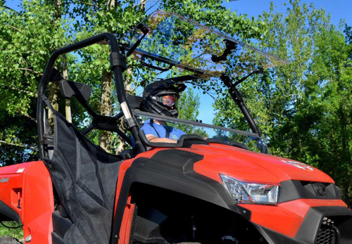 SuperATV flip-up windshield with the top half open on a red Kymco UXV 450, helmeted driver seated, front angle view