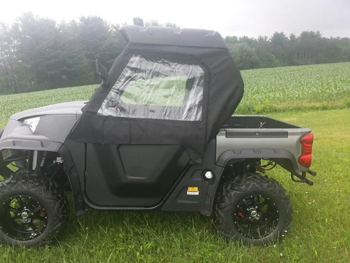 Side X Side black cab enclosure with clear windows installed on a gray Odes Dominator X2 LT, driver side view in a field