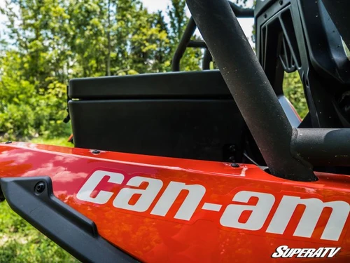 SuperATV cargo box mounted behind the roll cage above the red rear fender of a Can-Am Maverick, close side view
