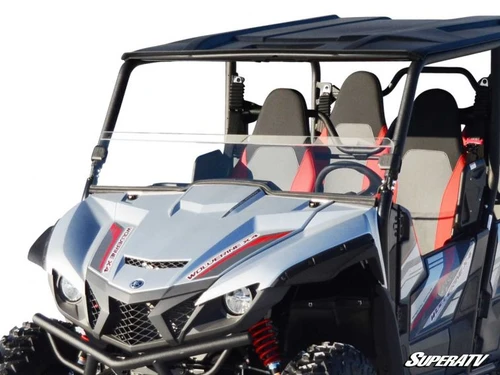 SuperATV half windshield installed on a gray four-seat Yamaha Wolverine, front three-quarter view in snow
