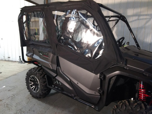 Side X Side full cab enclosure with doors and rear window on a gray Honda Pioneer 1000-5 in a shop