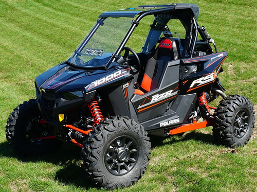 Black Polaris RS1 in a field fitted with a Spike Powersports rear windshield, front three-quarter view