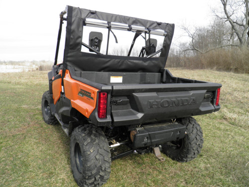 3 Star soft back panel with rolled-up rear window on an orange Honda Pioneer 1000, rear three-quarter view in a field