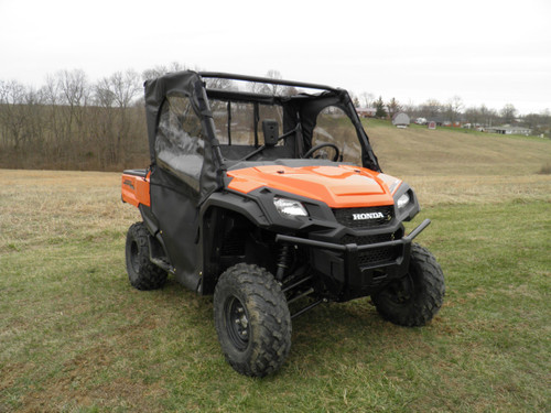 3 Star soft doors and rear window installed on an orange Honda Pioneer 1000, front three-quarter view in a field