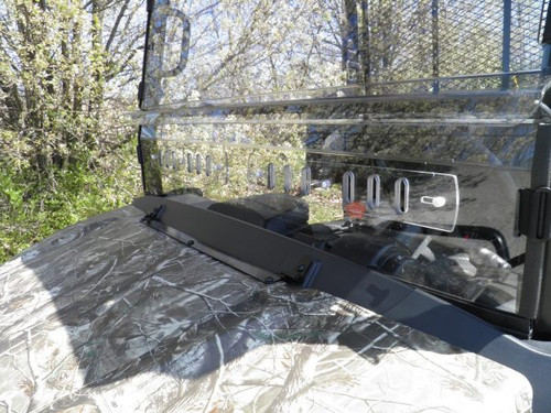 Close-up over the hood of the 3 Star two-piece windshield lower panel, hinge strip and vent slots on the Kubota RTV