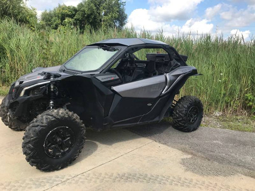 Side view of the gray Can-Am Maverick X3 with the Extreme Metal Products aluminum roof on pavement