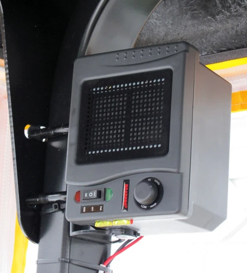 Wiedmann Bros 12-volt heater mounted under a cab panel with the power wires connected, installed view