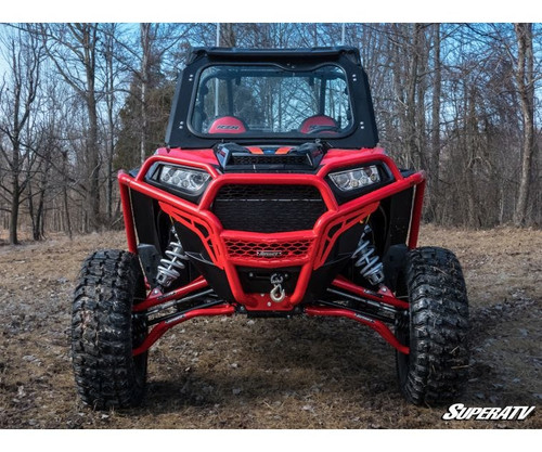 SuperATV 3-inch lift kit installed on a red Polaris RZR XP Turbo with red A-arms, front view in the woods