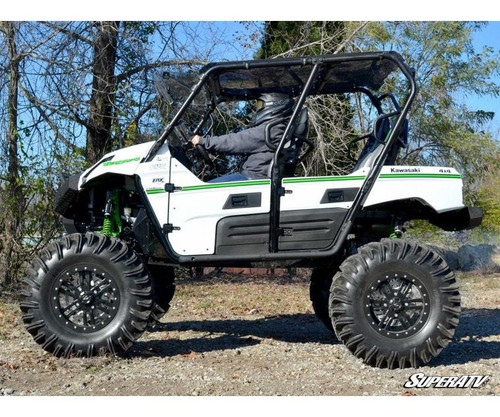 SuperATV heavy duty nerf bars installed on a white lifted Kawasaki Teryx 4 with mud tires, side view