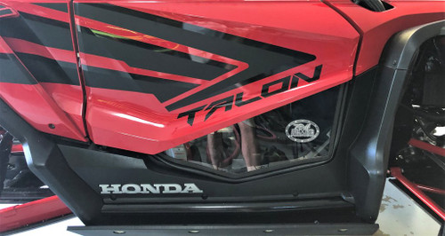 Trail Armor black lower door insert installed on a red Honda Talon 1000 door, side view in a shop