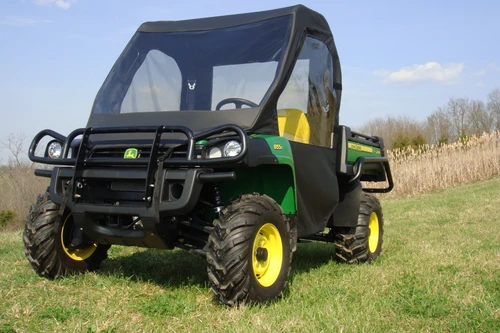 Front view of the green John Deere Gator XUV with brush guard and the 3 Star full cab with clear vinyl windshield