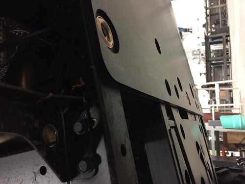 Close-up under the frame of the Universal Parts UHMW skid plate edge bolted beneath a Polaris Ranger XP 900