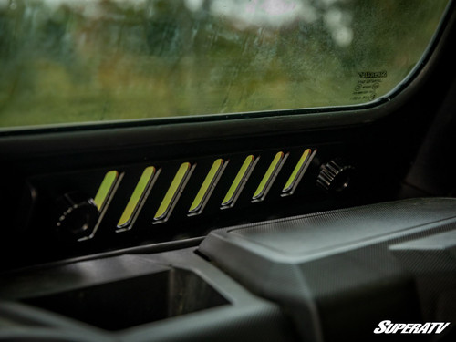 Close-up from inside the cab of the SuperATV glass windshield sliding vent slots and lock knobs above the dash