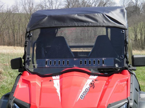 Front view of the 3 Star windshield and a soft top on a red CFMoto ZForce 800 on a grassy hill