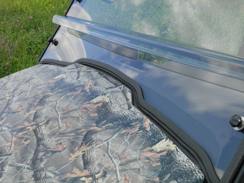 Close-up of the 3 Star windshield lower edge with rubber trim on the camo hood of the John Deere Gator