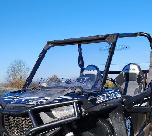 3 Star clear one-piece windshield on a blue and black Polaris RZR 900, front 3/4 close-up outdoors