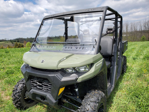 3 Star clear two-piece windshield with vent slots on a green Can-Am Defender Max, front 3/4 view on grass