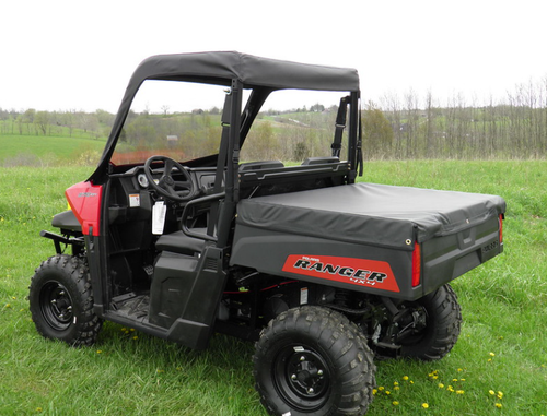 Rear three-quarter view of a red Polaris Ranger 570 midsize with the 3 Star vinyl top, rear window and a bed cover