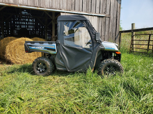 3 Star full cab enclosure on a CF Moto UForce 1000, black cab with clear windows, side view beside a barn