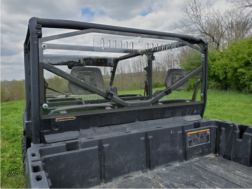 3 Star Lexan rear window with vent slots installed on a Can-Am Defender Max, seen from the cargo bed in a field