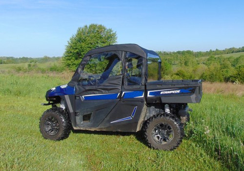 3 Star soft doors and rear window combo on a blue Arctic Cat Stampede, full side view in a green field