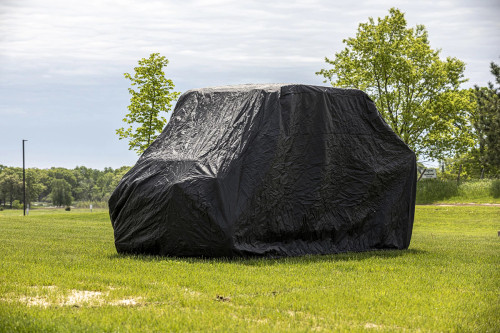 Kolpin black dust and rain cover fitted over a full-size crew UTV parked on grass, side view