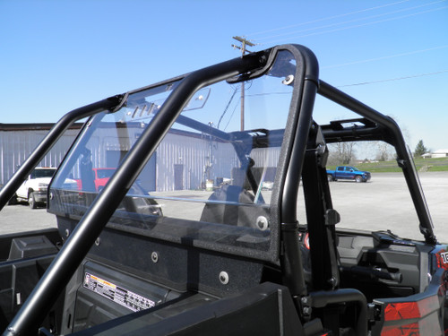 Side view of the 3 Star clear Lexan back panel in the cage behind the seats of a Polaris RZR 900 in a parking lot