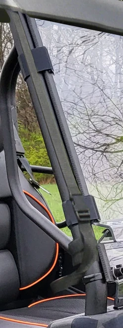 Narrow view of the 3 Star soft top strap and clip on the cage pillar of a green Intimidator GC1K