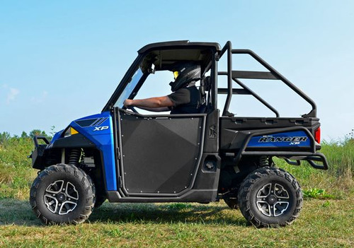 Full side view of the blue Polaris Ranger XP with SuperATV aluminum doors and a driver seated, in a field