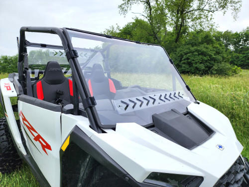3 Star tinted full front windshield on a white Polaris RZR XP 1000 with red seats, front three-quarter view in a field