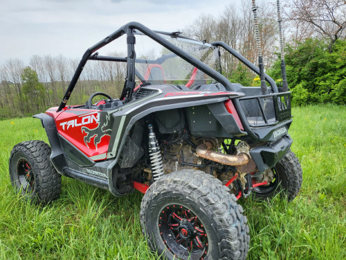3 Star one-piece Lexan back panel behind the seats of a red Honda Talon 2-Seater, rear three-quarter view in grass