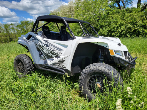 3 Star black soft top on a white Arctic Cat Wildcat XX, front three-quarter view in tall grass